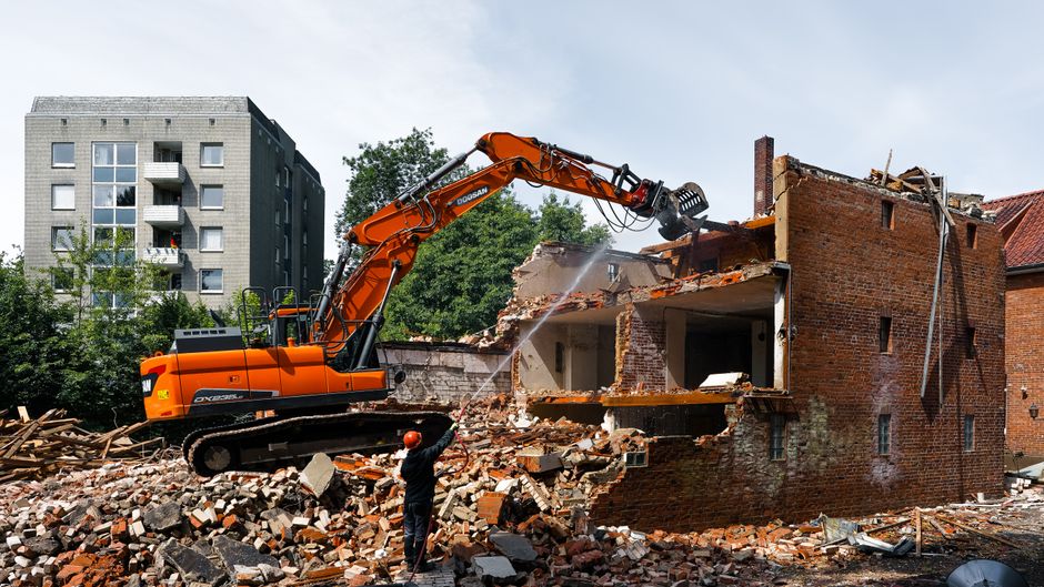An excavator demolishing an old building.