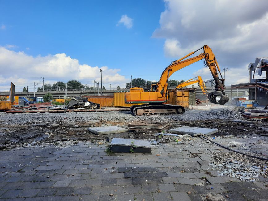 A bright yellow excavator working on a construction site.